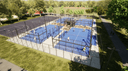 Luchtfoto van outdoor padelbanencomplex met blauwe QuickPadel-velden, omgeven door metalen gaas, groen landschap.