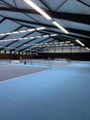 Overdekt padelcomplex met blauwe QuickPadel-banen, glazen wanden en LED-verlichting