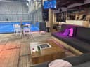 Moderne binnenpadelclub met blauwe QuickPadel-banen, bar en loungeruimte