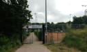 Ingang TV Epe padel club met rode gravel courts omheind door hekwerk