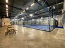 Moderne indoorbaan in padel club met blauwe hardcourt en zwarte omheining