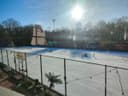 Outdoor padelbanen met blauwe QuickPadel velden en verlichting, omgeven door bomen