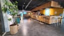 Moderne padelbaan met bar, houten afscheiding en grijze betonnen vloer