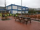 Padelclub met blauw-witte clubhuis, terras met stoelen en houten picknicktafels